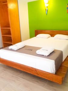 1 dormitorio con 2 camas y pared verde en La Quinta Loft Apartments, en Iquitos
