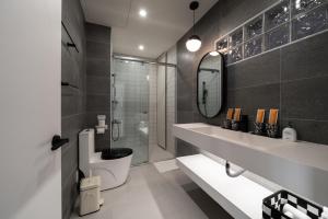 a bathroom with a sink and a toilet and a mirror at 双層公寓 Duplex Apt. in Tainan