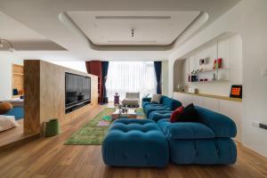 a living room with blue couches and a tv at 双層公寓 Duplex Apt. in Tainan