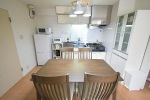 a kitchen with a table and chairs in a room at coco de minpaku in Sumiyoshi