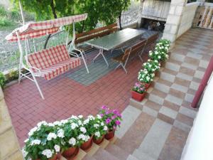 un patio con mesa, sillas y flores en Apartments Maca - seaview & private parking, en Zablaće