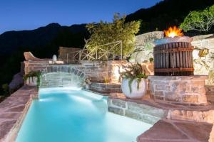 una piscina en un patio trasero con una fuente de fuego en Villa Three holiday homes, en Orebić