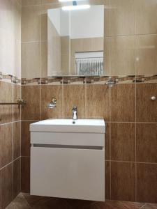 y baño con lavabo blanco y espejo. en Apartments Maca - seaview & private parking, en Zablaće