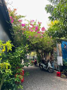 a group of motorcycles parked under an arch with flowers at Angkor Piseth Homestay in Siem Reap