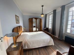 1 dormitorio con cama blanca y espejo en Vintage holiday apartment on the 1st floor of an elegant mansion - Coutances, en Coutances