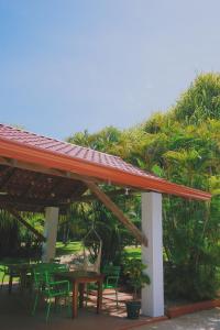 una mesa de picnic y sillas bajo un techo en Hotel Villa Del Sol, en Coco