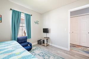 a bedroom with a bed and a blue chair at Sea Breeze Retreat in Navarre
