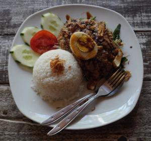 une plaque de nourriture à base de riz, de viande et de légumes dans l'établissement Kiayazo ViBES Inn, à Gili Trawangan