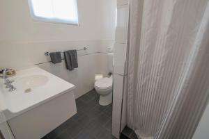 a white bathroom with a sink and a toilet at Bermagui Motor Inn in Bermagui