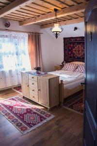 ein Schlafzimmer mit einem Bett, einer Kommode und einem Fenster in der Unterkunft Pensiunea Marioara in Breb