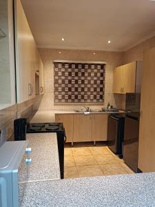 a kitchen with a sink and a stove top oven at AFYZ Mansions in Lenasia