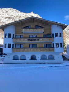een gebouw met een berg op de achtergrond bij Garni Apart Wallamotta Silvretta Card Premium Betrieb in Galtür