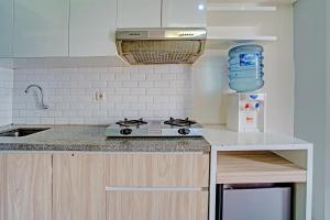 a kitchen with a stove and a counter top at OYO Life 92976 Apartement Jarrdin By Apato in Bandung