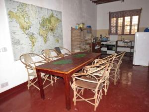 Una mesa y sillas en una cocina con un mapa en la pared. en Red Roof holiday home, en Jambiani