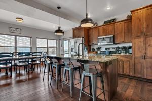 a kitchen with wooden cabinets and a large island with bar stools at Rockwood Lake Lodge- Sleeps 12 lodge in Branson