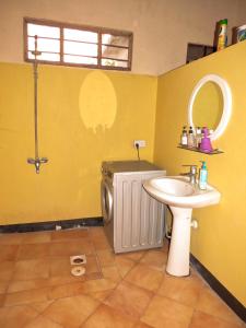 Un baño con lavabo, inodoro y espejo. en Red Roof holiday home, en Jambiani 9 fotos más