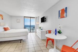 una camera d'albergo con letto, tavolo e tavolo di Romantic Oceanfront Studio Escape w Perfect View 1212 a Myrtle Beach