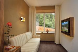 ein Wohnzimmer mit einem weißen Sofa und einem Fenster in der Unterkunft Hotel Madatsch in Trafoi