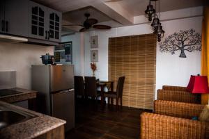 een keuken met een koelkast en een tafel met stoelen bij G Apartment - Home in Kabankalan City in Kabankalan