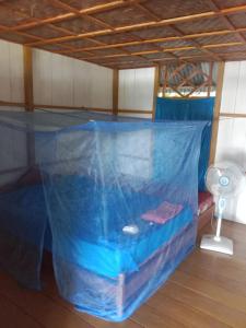 a bed in a room with a blue tarp at Lestari Cottages in Kododa