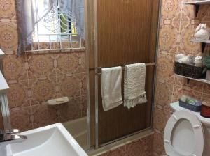 a bathroom with a shower with a toilet and a sink at Homely Escape in Montego Bay