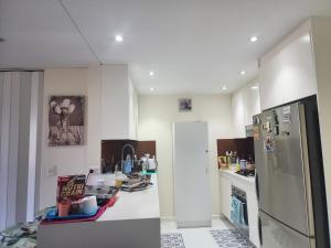 a kitchen with a refrigerator and a counter top at Parramatta Shared Apartment in Sydney