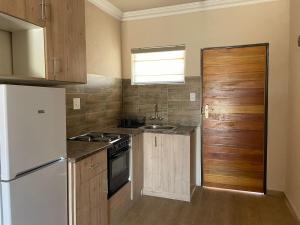 a kitchen with a white refrigerator and a sink at Sekgome Resort in Johannesburg