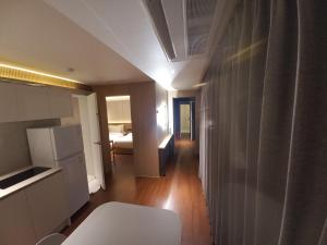 Zimmer mit einer Küche und einem Zimmer mit einem Bett in der Unterkunft Adena Hotel in Busan