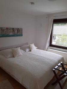a white bed in a bedroom with a window at Ferienapartment Ida in Lorch