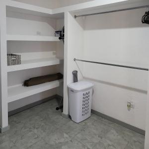 a bathroom with white shelves and a toilet at Departamento N° 2 in Nuevo Laredo