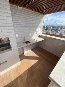 a bathroom with a sink and a large window at Lindo e novo apto com vista para o mar de Pituba c/garagem in Salvador