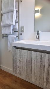 a bathroom with a white sink and towels at Waterscape Apartment in Akaroa