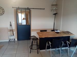 a room with a counter with chairs and a blue door at Nid douillet in Genilac +11 photos