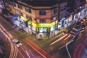 una concurrida calle por la noche con coches y autobuses en HOTEL CASA LUNA, en Piura