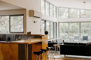 - une cuisine avec un comptoir et quelques fenêtres dans l'établissement Parsons Cove Beach House, à Coles Bay