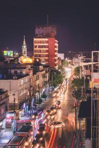 Una calle concurrida de noche con coches en HOTEL CASA LUNA, en Piura