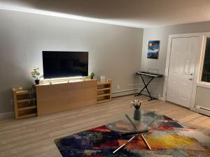 a living room with a tv and a glass table at Perfect Stays in Edmonton