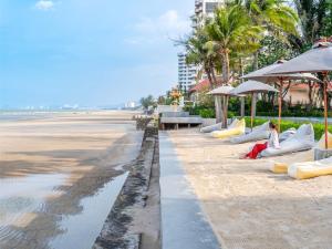 a beach with people laying on inflatables on the sand at RELO' The Urban Escape - Huahin in Cha Am