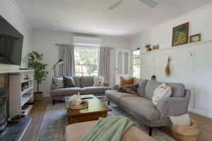 a living room with a couch and a table at Golden Pine Retreat in Bright