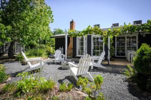 a garden with white chairs and a pergola at Golden Pine Retreat in Bright