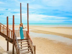 Una mujer con un vestido azul parada en la playa en RELO' The Urban Escape - Huahin en Cha Am