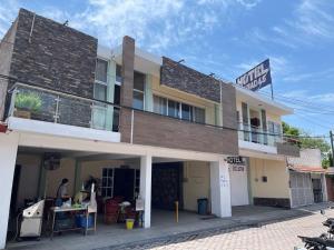 a man is standing outside of a building at Hotel Cañada's & Bungalows in Villa Corona
