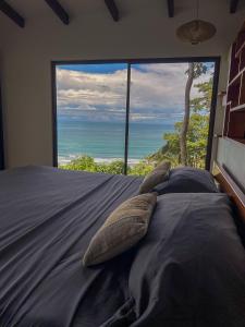 a bedroom with a bed with a view of the ocean at La Uvita Perdida in Uvita