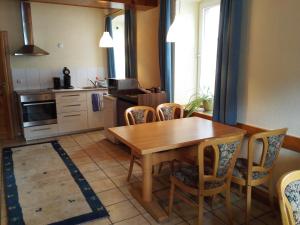 a kitchen with a wooden table and chairs at Gästehaus Krone in Oberndorf