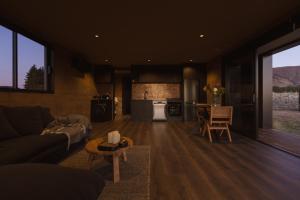 a living room with a couch and a kitchen at The Rise, Ben Ohau in Twizel