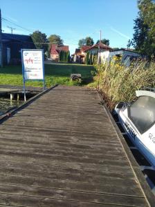 drewniana przystań z znakiem obok łodzi w obiekcie LEŚNA OSADA w mieście Tuchlin