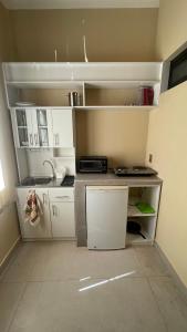 una pequeña cocina con armarios blancos y fregadero en Bernardo’s Departamento céntrico para 2 o hasta 3 personas en Sucre