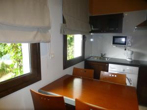 a small kitchen with a wooden table and chairs at La Casina de Torra in Ribadesella