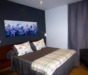 リバデセリャにあるLa Casina de Torraのベッドルーム1室(ベッド1台付)が備わります。壁には絵画が飾られています。