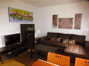 a living room with a couch and a flat screen tv at La Casina de Torra in Ribadesella